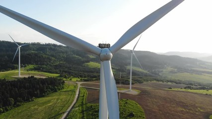 aerial view of clean and renewable wind power farm in motion konverting kinetic energy modern electric industry environmental protection innovation ecosystem electricity generator wind turbines - Powered by Adobe