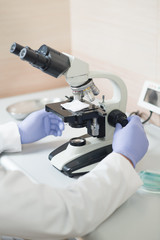 Young scientist doctor looking into the microscope at the laboratory