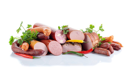 Different sausages and smoked meats isolated on white .