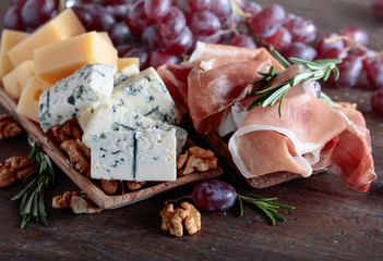 Prosciutto with various cheeses , grapes and  walnuts .