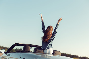 Happy traveler woman in cabrio car