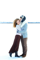 Female person hugging boy wearing winter hat and mittens in winter background. Concept of seasonal...