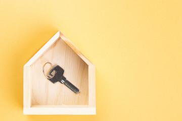 A key from home on yellow background. Copy space