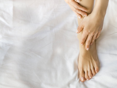 Close up of woman's leg with moisturizing cream.