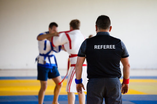 The sports judge follows the struggle of two athletes kuresh on tatami 
