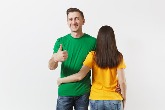 European young brunette woman, smiling man showing thumbs up, football fans in yellow green empty t-shirt isolated on white background. Sport play soccer cheer fan people lifestyle concept. Back view.