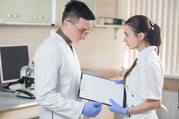 Obraz premium Young doctor or scientist with his assistant in lab. Team working