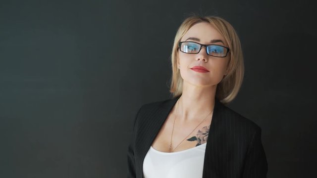 the business woman teacher with glasses and a suit. Put on and adjust the glasses before class