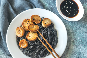 Portion of black pasta with king oyster scallops