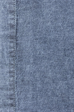 Old blue denim jeans texture or background with visible fibers and stitch
