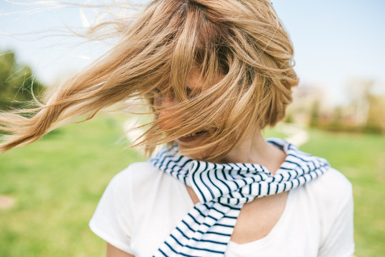 Close Up Portait Of Romantic Happy Female With Blond Blowing Hair Enjoy Weather And Sunny Day Outside. Portrait Of Beautiful Young Woman Smiling With Windy Hair On Face In The Park. People, Lifestyle