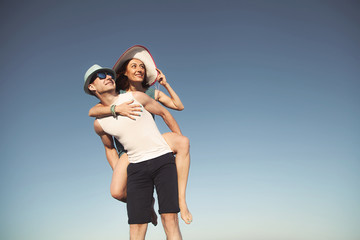 Portrait of a beautiful young couple against a blue sky background.