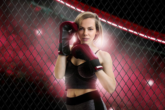 charming blonde woman mma fighter in red corner of the cage looking at the camera