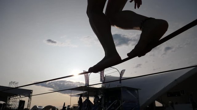 Young girl legs silhouette walking balancing on slackline rope the modern sport activity