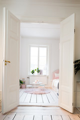 fancy bedroom, white wooden floor open doors looking into the bedroom