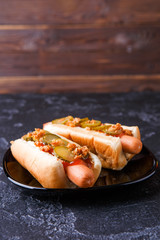 Photo of hotdogs on black plate