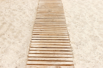 Wooden beach boardwalk with sand for background