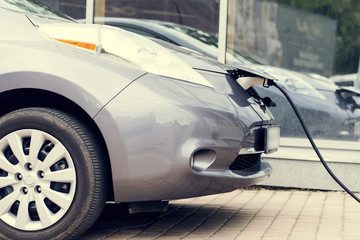 .The electric car is on a charge..Close-up.Toned