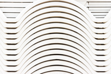 Folded stack of white plastic deck chairs. beach loungers background or texture. close-up