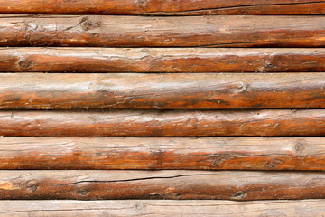 wall made of wooden logs background. wooden beams fence texture