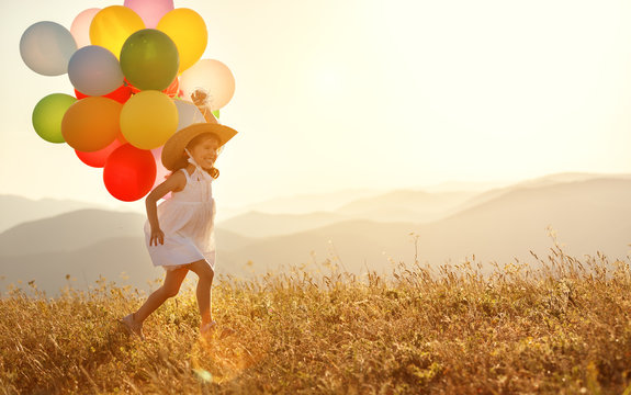 happy child with balloons at sunset in summer.