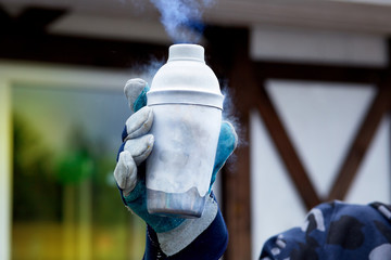 hand in glove holding a jar of liquid nitrogen