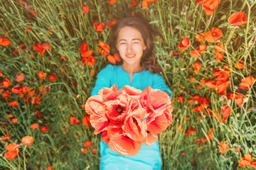 Obraz na płótnie Canvas Happy young woman lying on flower meadow.