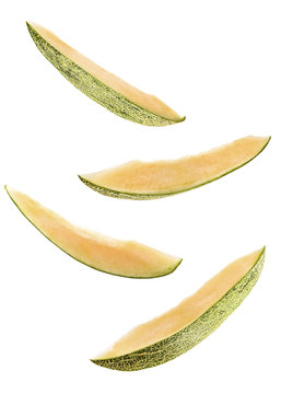 sliced flying melon isolated on white background. cut melon fruit in pieces isolated on white background. Levity fruit floating in the air