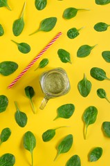 Freshly prepared green smoothie on yellow background