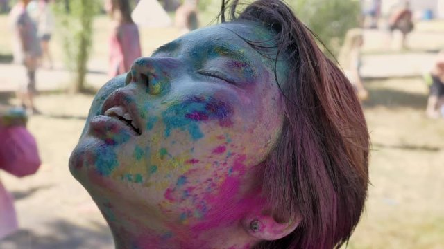 Young happy asian girl is frashing up under rain on holi festival in daytime in summer, color concept, emotional concept