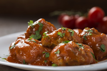 Meatballs with tomato sauce and fresh chopped parsley on plate