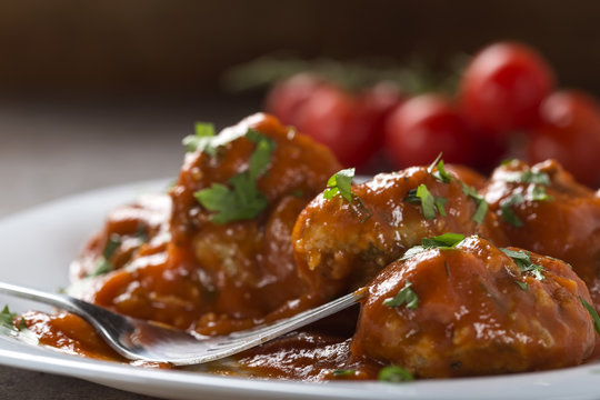 Meatballs with tomato sauce and fresh chopped parsley on plate