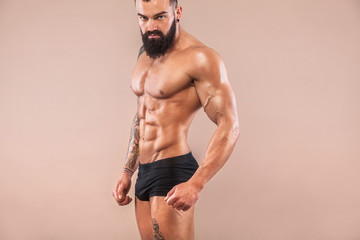Muscular young fitness sports man with strong fit body on light background.