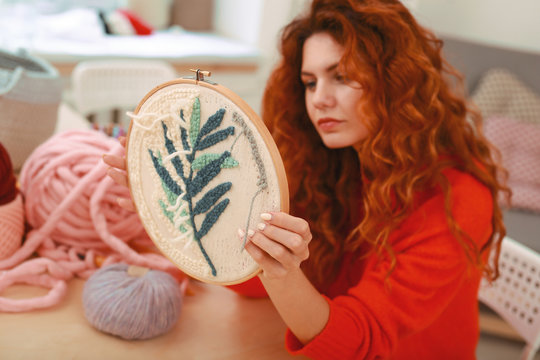 Enthusiastic girl. Enthusiastic young girl feeling extremely imaginative while embroidering little branch