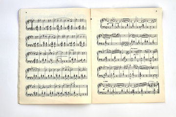 Book with musical notes. A musical book with musical notes on light background, top view.