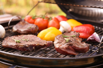 Modern grill with meat and vegetables outdoors, closeup