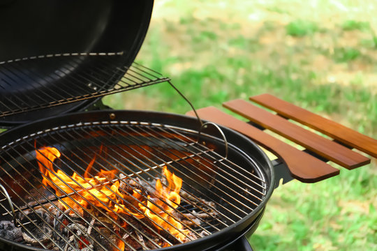 Modern barbecue grill with fire flames outdoors, closeup
