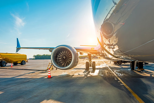 Fototapeta Sunset at the airport. Refueling of the airplane before flight, aircraft maintenance fuel at the airport.