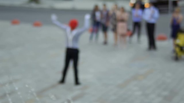 Mime at blurred background of fountain communicate with people
