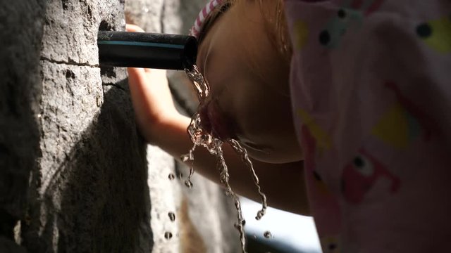 Kid girl mouth closeup quench thirst drink water from mountain clean pure sourse equipped with a tube for convenience in Sofia Bulgaria Vitosha national park