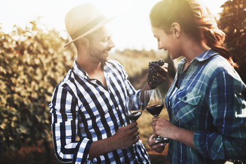 People tasting wine in vineyard