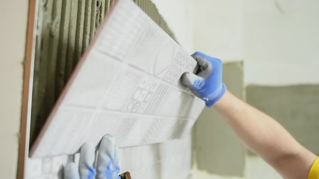 tiler installing ceramic tile panel in kitchen