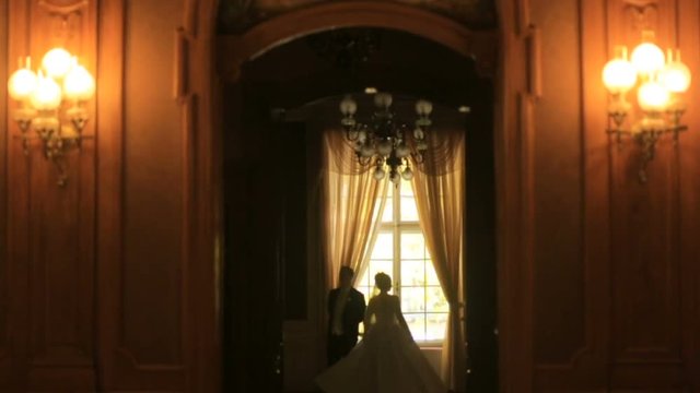 Beautiful couple of newlyweds are dancing in the old baroque style castle.