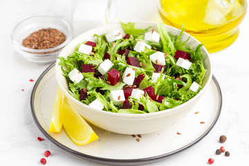 Salad with lettuce, boiled beets, feta cheese, flax seeds and lemon
