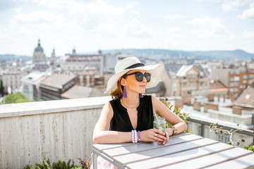 Woman enjoying great cityscape view from the terrace on the old town with saint Stephen cathedral in Budapest city, Hungary