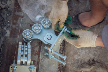 The worker installs rollers on the sliding gate