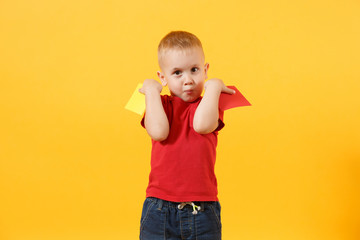 Little cute kid baby boy in red t-shirt holding in hand yellow and red soccer referee cards for...
