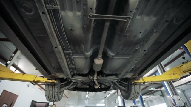 working under a lifted car. Garage service. Automobile diagnostic