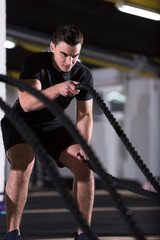 Fototapeta na wymiar athlete man doing battle ropes cross fitness exercise