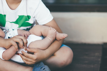 Obraz na płótnie Canvas boy is holding his youngest newborn brother
